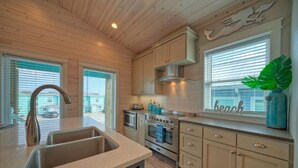 Una cocina moderna con armarios de madera, electrodomésticos de acero inoxidable y un ventanal con vistas al exterior.
