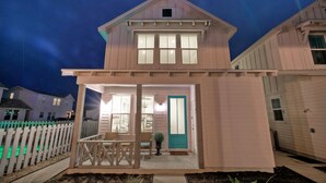 A two-story house with a porch, a door with a window, and a small window above the door. - Pool | 1 Block to Alister + Old Town + Eateries | Bluegrass Breeze by AvantStay (Port Aransas)