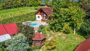 Ein Haus mit Schwimmbad, umgeben von üppiger Vegetation und einem eingezäunten Garten.