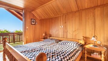 A wooden room with a bed, nightstands, and a view of the outdoors.