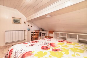 A bedroom with a bed, a desk, a chair, and a radiator. - Pool Chalet Adonis w/ Panoramic Views (Semič)
