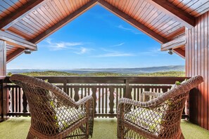 A wooden balcony with wicker chairs and a view of a green landscape. - Pool Chalet Adonis w/ Panoramic Views (Semič)