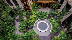An aerial view of a rooftop garden with various plants and a circular seating area. - REY Hotel Hanoi (Hanoi)