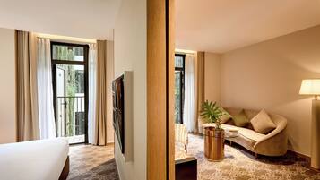 A hotel room with a bed, a sofa, a coffee table, and a TV.