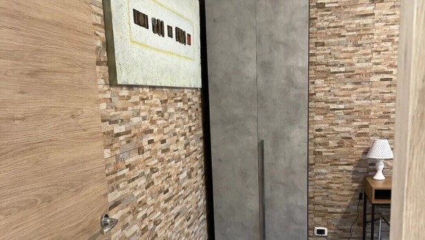 A room with a wooden wall, a grey wardrobe, and a tiled floor. - Casamagnolia, your home (Cernusco sul Naviglio)