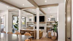 Enjoy meals and entertainment in this spacious kitchen and dining area, featuring a large flat-screen TV, dining table, and comfortable seating.