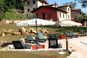 Relax in a serene outdoor seating area surrounded by a traditional stone building.