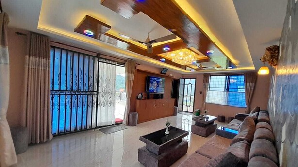 A spacious living area with a modern design, featuring a large sofa set, a coffee table, and a television. - York  Air Home (Kathmandu)
