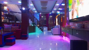 A modern bar area with a staircase, seating, and a television screen. - York  Air Home (Kathmandu)