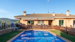 Il s’agit d’une propriété résidentielle dotée d’une piscine, d’une cour arrière clôturée et d’une maison avec un toit en tuiles.