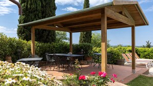 A covered patio with tables and chairs, surrounded by greenery and flowers. - Villa 'La Petrosa' with Private Pool, Private Garden and Balcony (Radda in Chianti)