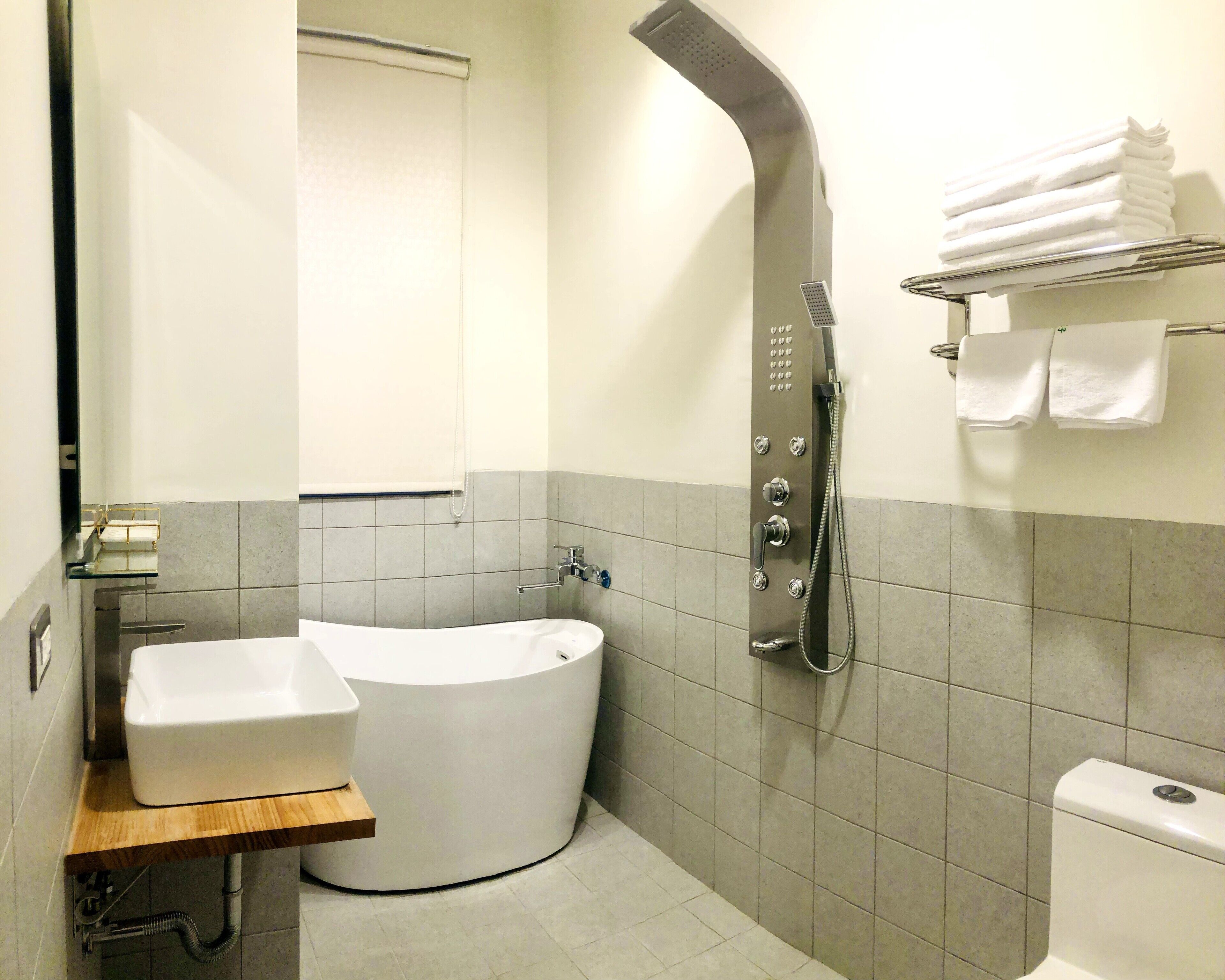 Un bagno moderno con una vasca freestanding, un lavandino e un soffione.
