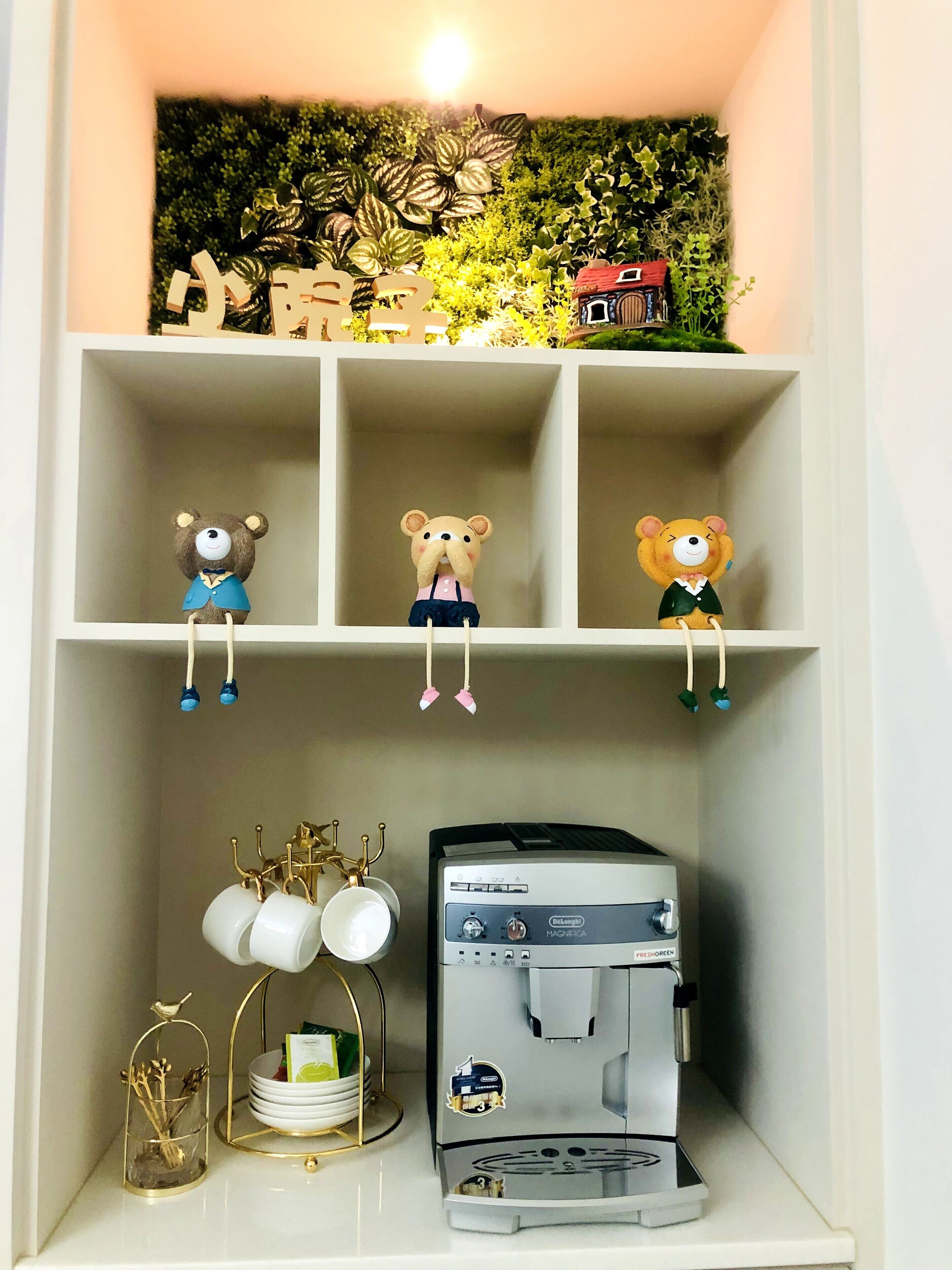 A shelf with three bear figurines, a coffee machine, and a small plant.