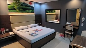 A modern hotel room with a large bed, bedside tables, a desk, and a chair. There are two mirrors on the walls and a painting above the bed. - Hotel Sogo Davao (Davao)