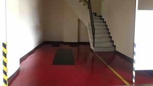 A parking garage with a red floor, a staircase, and a 'Drive-In' sign. - Hotel Sogo Davao (Davao)