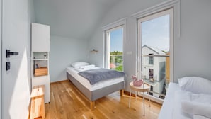 Ein modernes Schlafzimmer mit einem Bett, einem kleinen Tisch und einem Kleiderschrank.