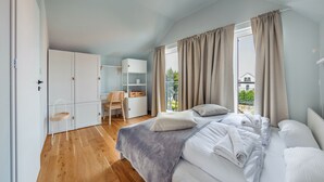 Ein Schlafzimmer mit Bett, Schreibtisch, Stuhl und Kleiderschrank.