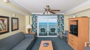 A room with a sofa, a coffee table, a TV cabinet, and a balcony with a view. - 2 BR Condo OF tons of Amenities! Low Floor (Myrtle Beach)