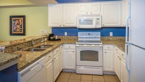 A kitchen with white cabinets, a granite countertop, a built-in microwave, and a stove. - Oceanfront 2 BR Condo tons of Amenities 9th Floor! (Myrtle Beach)