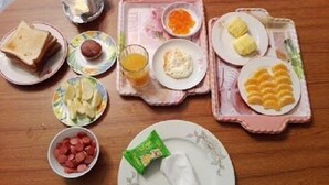 A breakfast tray with toast, fruit, eggs, and a packet of butter.