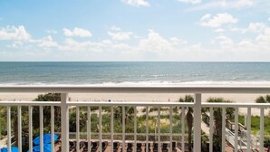Un balcon avec vue sur la plage et l’océan.