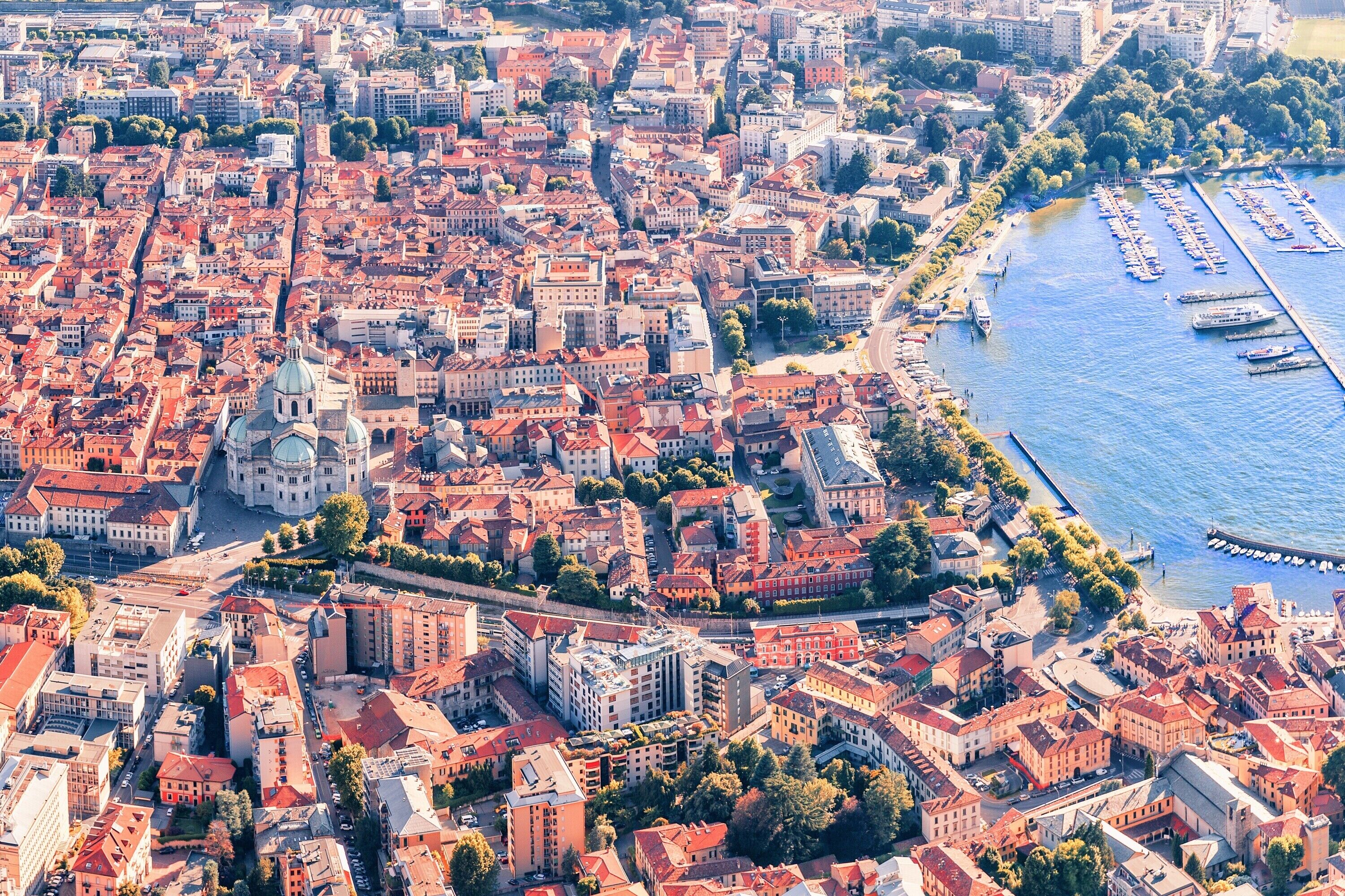 Vue aérienne d’une zone urbaine densément construite, avec une rivière et un port de plaisance.