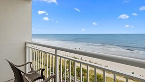 Een balkon met uitzicht op het strand en de oceaan.