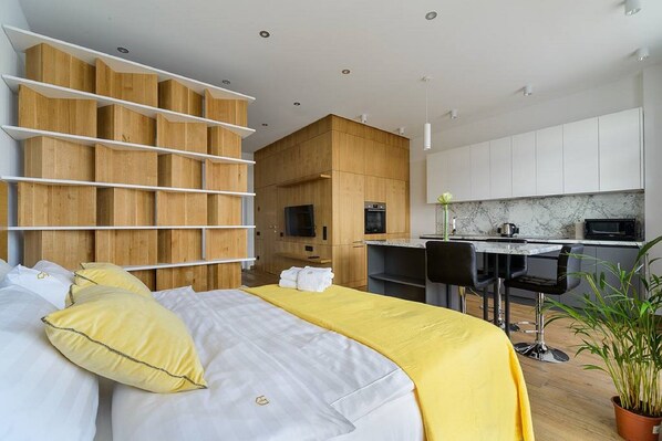 Una habitación de hotel moderna con cama, escritorio y zona de cocina.