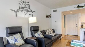 A modern living room with leather sofas, a floor lamp, and decorative wall art. - Boathouse Condo, Waterfront, Golf course, Destin Harbor.  Sandpiper Cove #1055 (Destin)