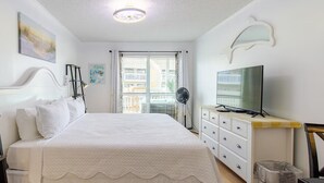 A bedroom with a bed, a dresser, a TV, and a window with blinds. - Boathouse Condo, Waterfront, Golf course, Destin Harbor.  Sandpiper Cove #1055 (Destin)