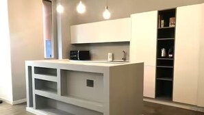 Eine moderne Küche mit integrierten Geräten, einer zentralen Kochinsel und Regale.