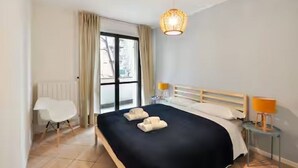 A hotel room with a bed, a chair, a bedside table, a lamp, and a window. - GuestHost - CASA CRI&ELI: trilo x5 con terrazzo (Milan)