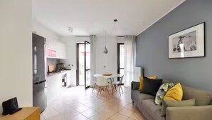A modern apartment with a dining area, kitchen, and living room. - GuestHost - CASA CRI&ELI: trilo x5 con terrazzo (Milan)