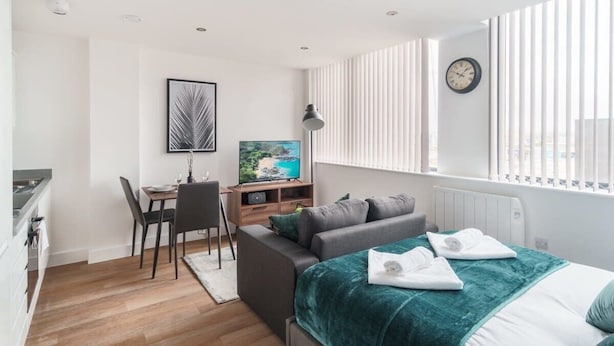 Un dormitorio moderno con cama, escritorio y silla.
