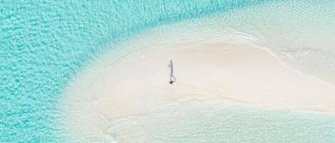 Una playa con agua turquesa cristalina y una zona arenosa.