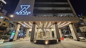 A modern building with a prominent logo and a covered entrance area.