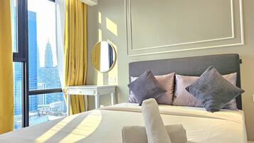 A hotel room with a large bed, a bedside table, a mirror, and a view of a cityscape through a window with yellow curtains.