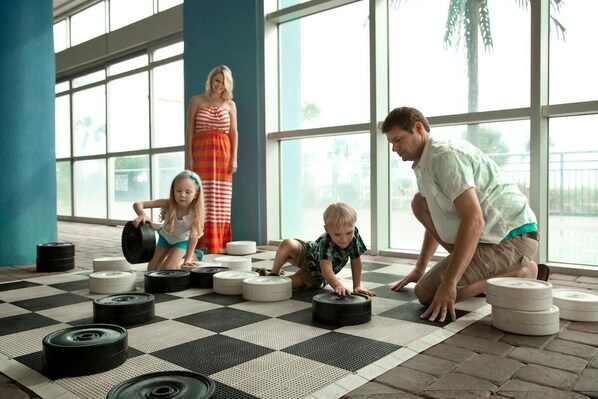 A spacious indoor area with large windows, a checkered floor, and exercise equipment.