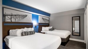 A hotel room with two beds, a large mirror, and artwork on the wall. - Oceanfront Tranquility: 2BR Retreat Dual Balconies (Myrtle Beach)
