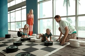 Guests can enjoy a fun workout session in this indoor space with a checkered floor, featuring a large window view of a palm tree.