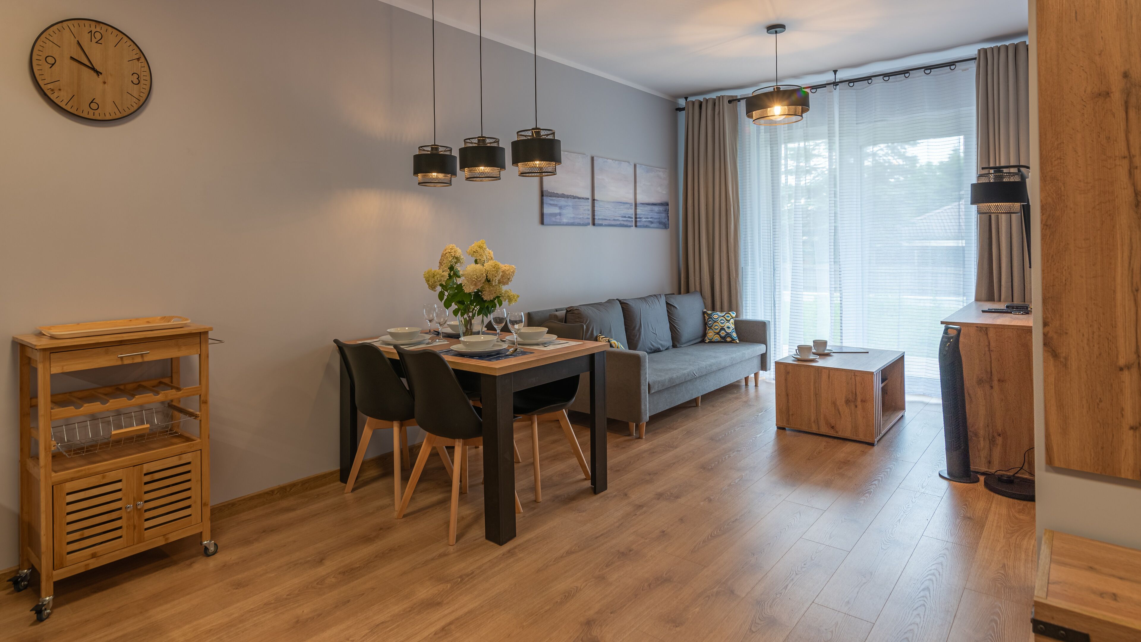 Ein modernes Wohnzimmer mit Essbereich, einer Couch, einem Couchtisch und einem Holzkasten.