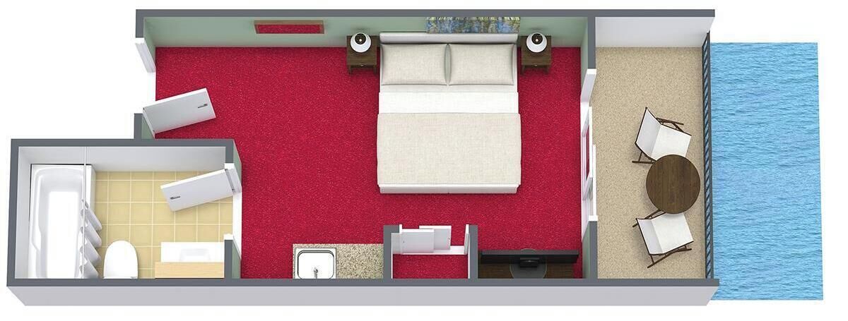 A hotel room with a bed, a bathroom, a seating area with a table and chairs, and a view of the water.