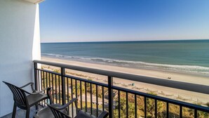 A balcony with a view of a beach and ocean. - Wave Watcher's Delight: Oceanfront King Escape (Myrtle Beach)