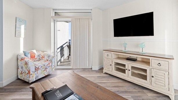 Un salon comprenant un canapé, une table basse, un téléviseur et un meuble.