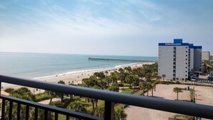 A beach view with a pier, a hotel, and a clear sky. - Tranquil Tides Retreat Two Balcony Oceanview Suite (Myrtle Beach)