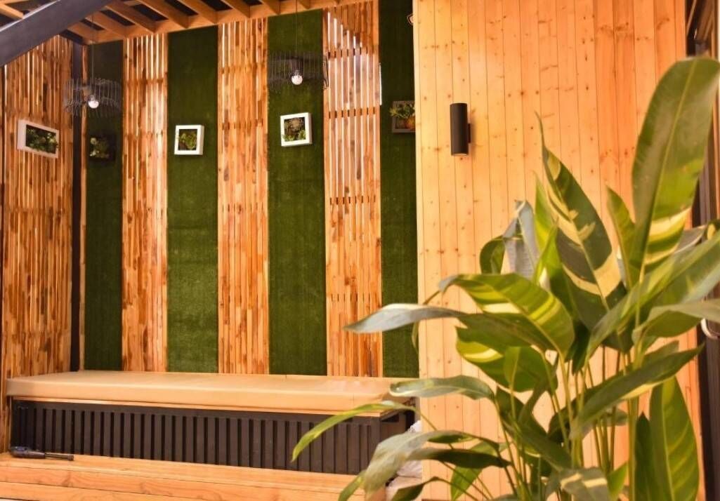 A wooden bench with a green wall in the background.