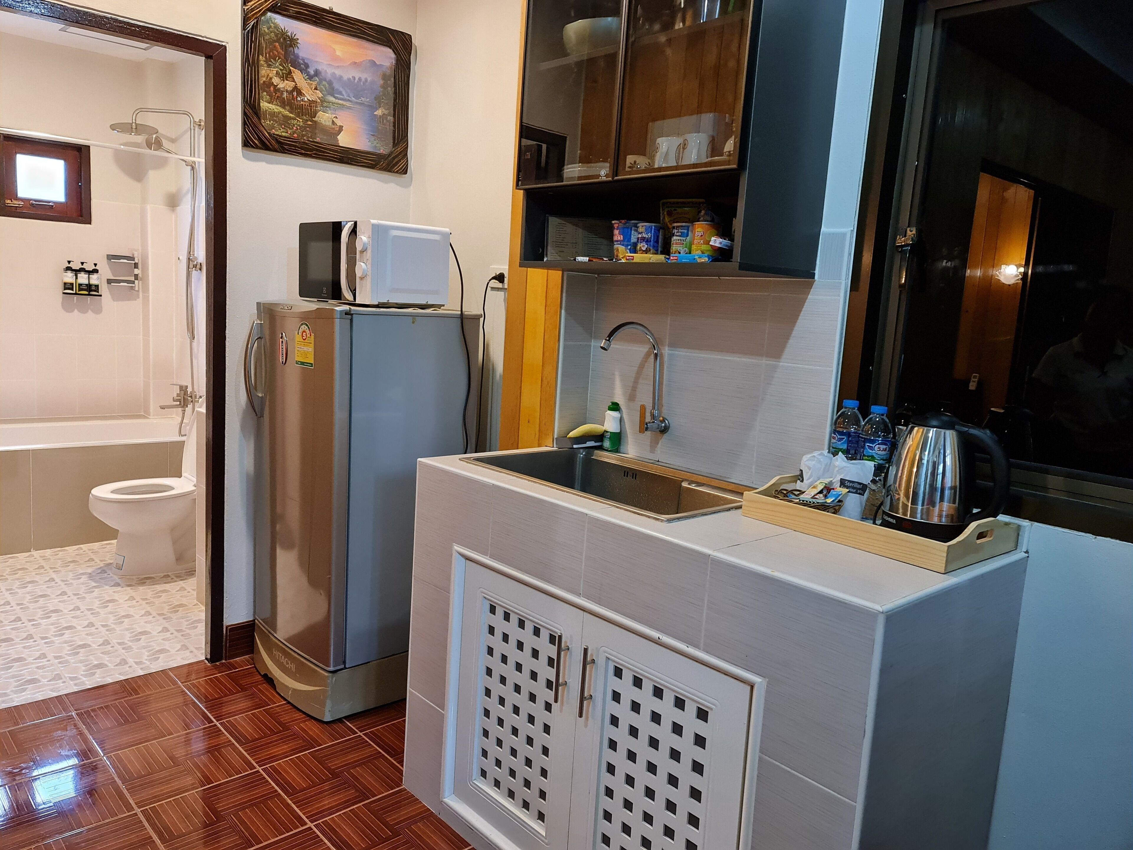 A compact kitchen with a sink, microwave, and refrigerator.