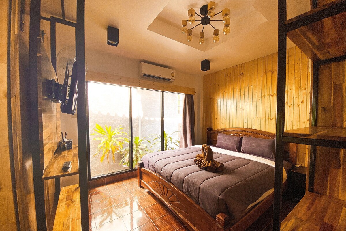 A bedroom with a wooden bed, a large window, and a ceiling fan.