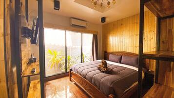 Un dormitorio con cama de madera, un ventanal grande y un ventilador de techo.