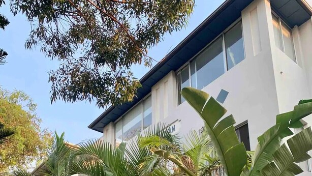 Un bâtiment moderne à l’extérieur blanc, doté de grandes fenêtres.
